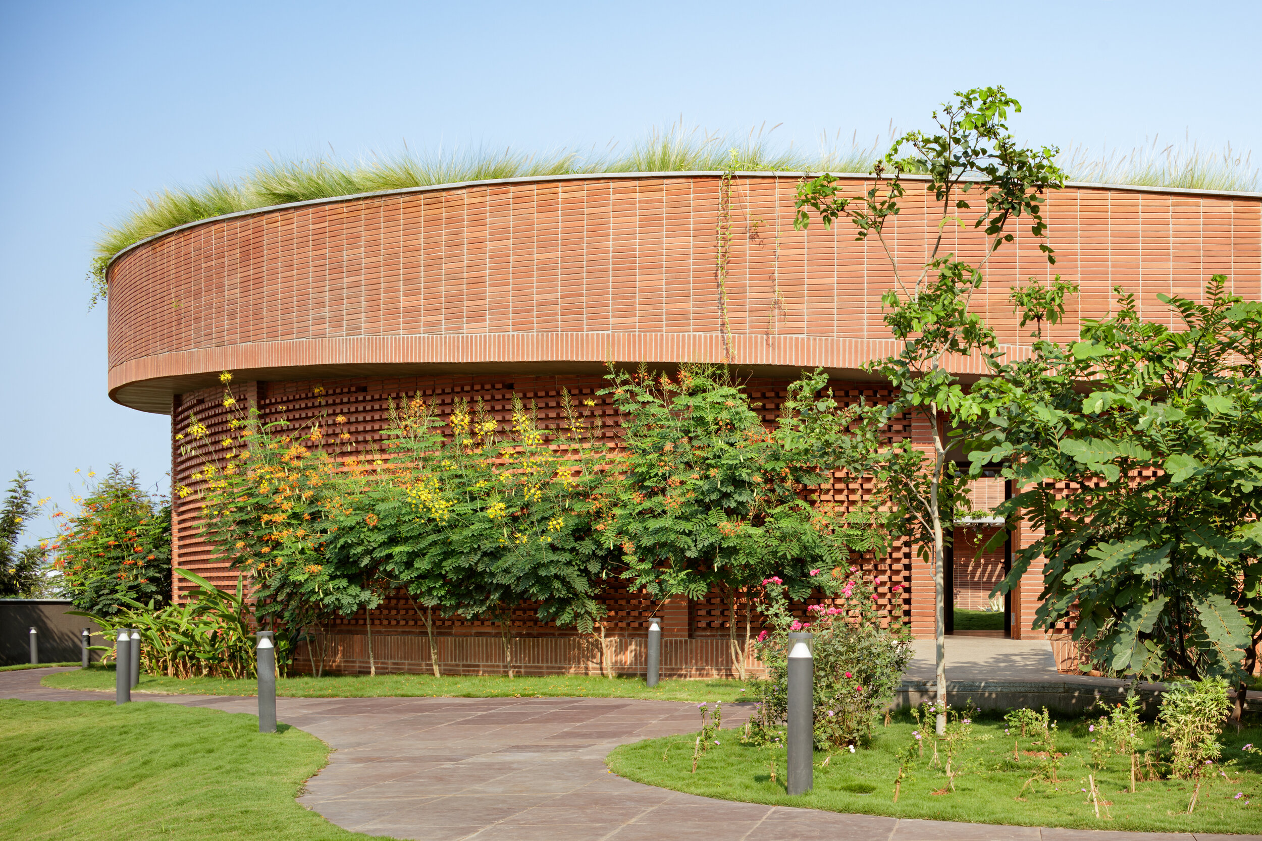 Circular brick building with living green roof at Total Environment