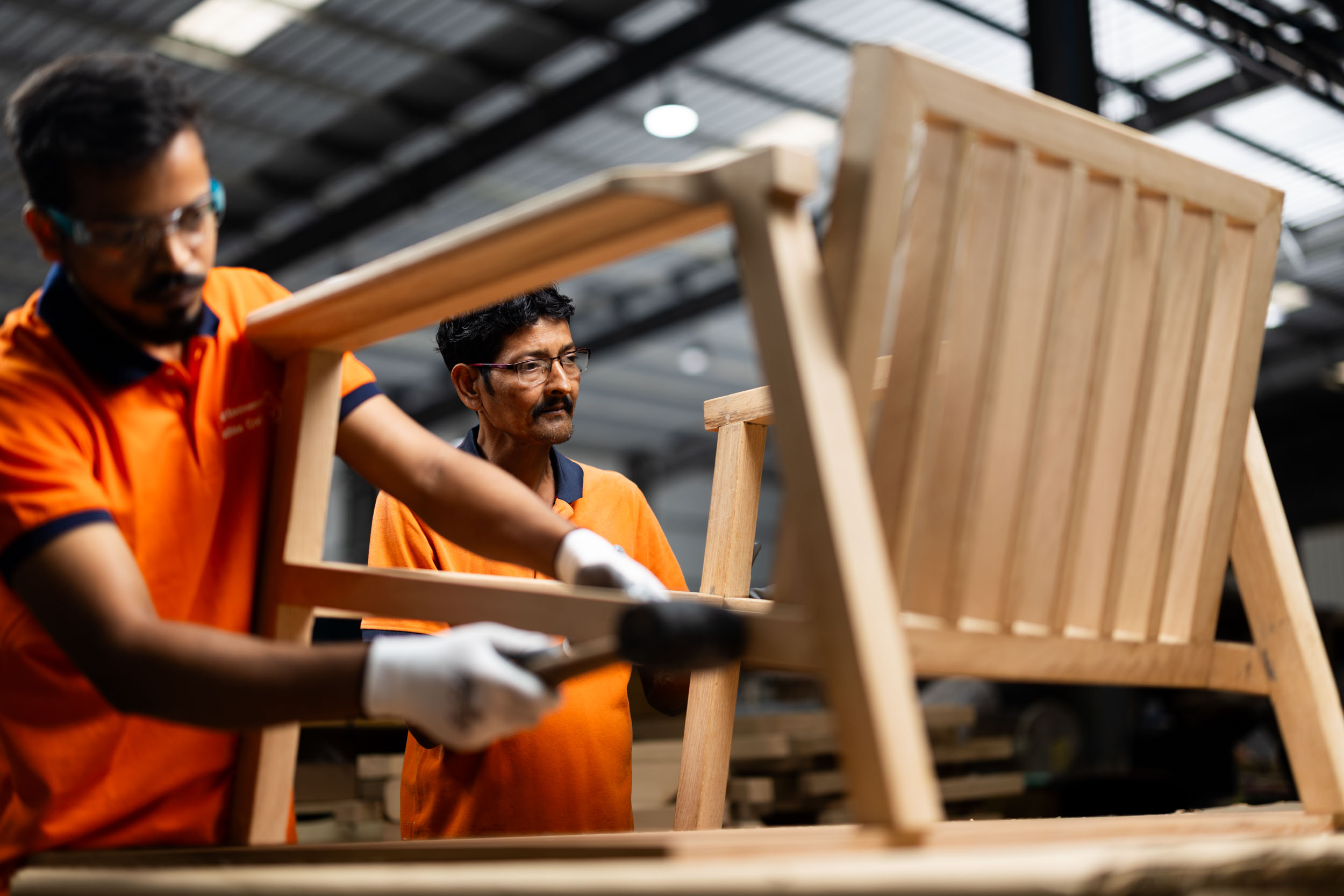 Two artisans assembling custom furniture frames at Machine Craft